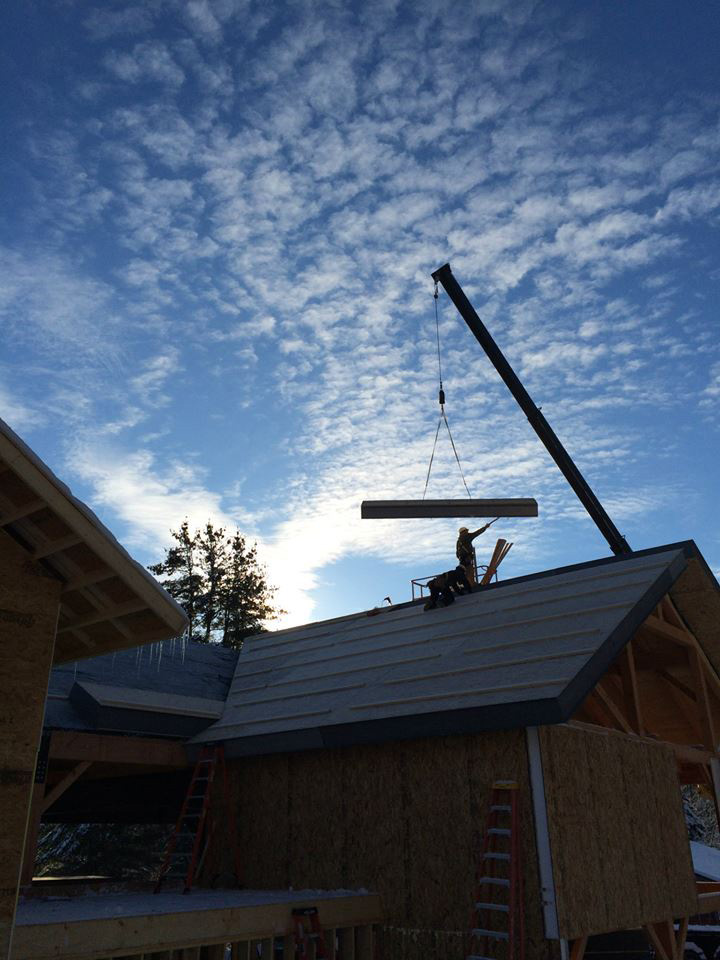 Roof SIPs being installed with a crane on a timber frame pavilion